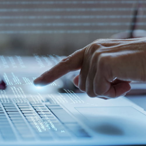 Photograph of a hand hovering over a keyboard ready to type