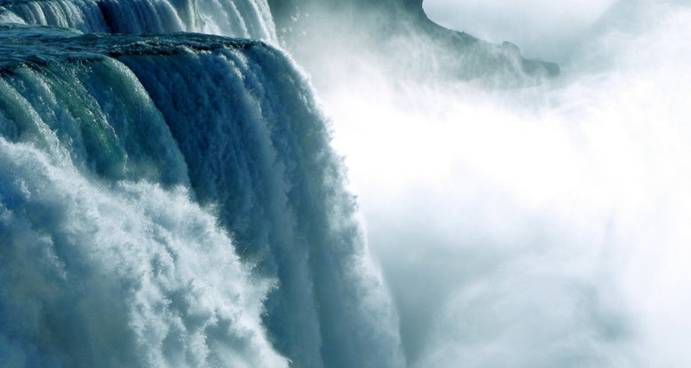 Photograph of a powerful waterfall creating lots of spray