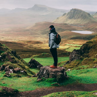 Photograph of a hiker standing in the centre of a beautiful landscape