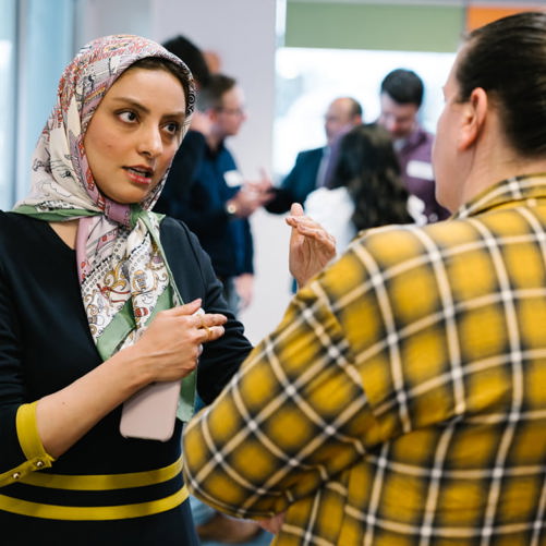 Photograph of a 2i employee explaining something to a colleague